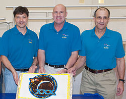 Soyuz TMA-03M crew during a cake-cutting ceremony.jpg