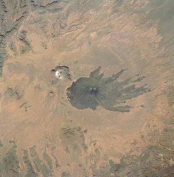 Image satellite du Tarso Toussidé avec le pic Toussidé au centre de la tâche sombre et le Trou au Natron en haut à gauche.