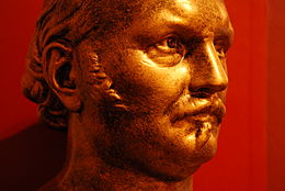 Buste d'Allan Kardec, fondateur du spiritisme. L'image est une photographie rapprochée d'un buste dorée représentant un homme d'une cinquantaine d'année, portant moustache et regardant droit devant.