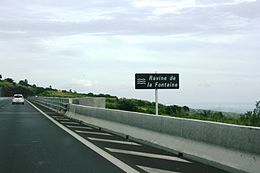 Panneau de signalisation routière indiquant la Ravine Fontaine le long de la route des Tamarins.