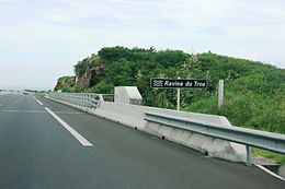 Panneau de signalisation routière indiquant la Ravine du Trou le long de la route des Tamarins.
