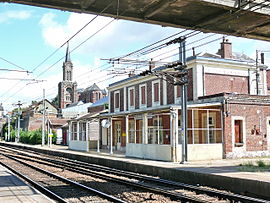L'intérieur de la gare avec le bâtiment voyageurs et les voies.