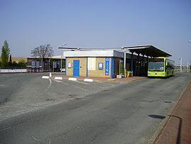 Bâtiment de la gare avec une navette bus pour l'aéroport