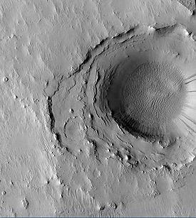Cratère d'impact au fond du cratère Cassini,révélant sa géologie complexe[1].