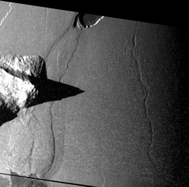 Une image de Tawhaki Vallis prise par Galileo en Novembre 1999.  La vallée suit approximativement une direction North-south sur le côté droit de l'image. Le nord est en haut de l'image. Le soleil illumine le terrain depuis la gauche.