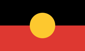 Drapeau 2:3 ; le haut est noir, le bas rouge, et un cercle jaune dont la hauteur vaut la moitié de celle du drapeau se trouve en son centre.