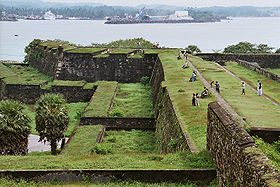 Fortifications, envahies de végétation, au bord de la mer