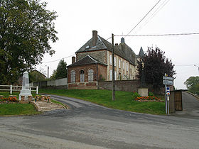 La rue contourne la butte où se dresse l'église avec son cimetière.
