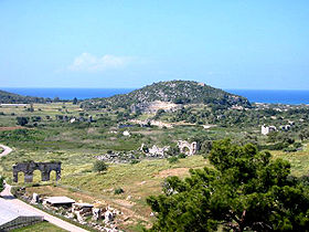 Une partie des ruines de Patara. On peut voir la porte de la ville en bas et à gauche et le théâtre sur le flanc de la colline.