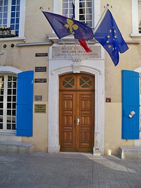 Façade de la mairie de Caderousse avec marques (plaques noires à gauche) des inondations historiques de 1827, 1840 et 1856