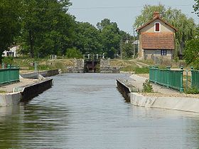 La rigole de l'Arroux juste avant son débouché dans le canal du Centre. Au premier plan, le pont-canal sur la Bourbince, à l'arrière plan, l'écluse de Neuzy.