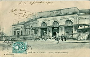 La gare de la Place Denfert-Rochereau, à l'époque où elle était le terminus de la ligne.Conçue du temps de la voie large du système Arnoux, la forme courbe des bâtiments permettait aux trains de desservir le terminus en tournant le long de la façade intérieure.