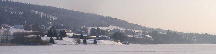 Vue panoramique du village de Malbuisson l'hiver, prise depuis le milieu du lac de Saint-Point gelé